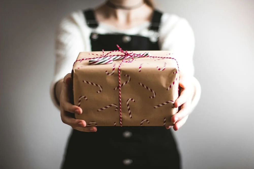 Primer plano de regalo original, tarjeta regalo para sesión de fotos profesional en Tarragona, ideal para parejas y familias.